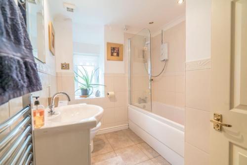 a bathroom with a sink and a tub and a toilet at Llwyn-Y-Coed-Isaf in Llanbedr-y-cennin