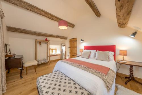 a bedroom with a large bed and a desk at The-Longbarn in Ruthin