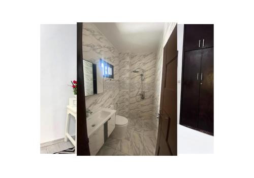 twee foto's van een badkamer met een bad en een wastafel bij River Side in Abidjan