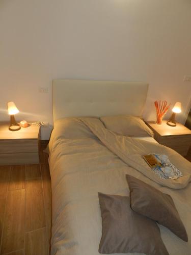 a bed in a room with two tables and two lamps at JeD SWEET DREAMS in LʼAquila