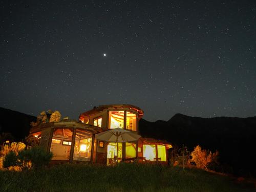 a building with lights on in the middle of the night at Swiss Eco Lodge La Linda Loma - Olmué in Olmué