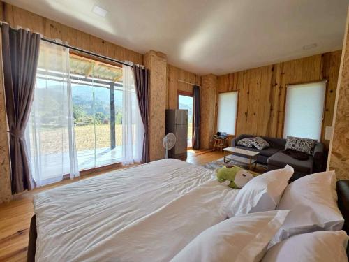 a bedroom with a large bed with a large window at บ้านพัก กามู Gamoo homestay in Chom Thong