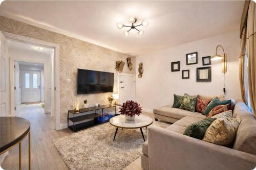 a living room with a couch and a tv at Jubilee View - New! Luxurious Home, Parking Wi-Fi in Bury