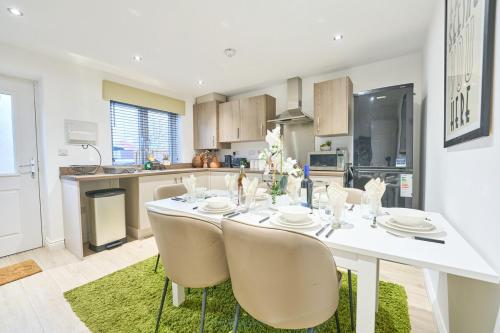 a kitchen with a white table and chairs in a room at Jubilee View - New! Luxurious Home, Parking Wi-Fi in Bury