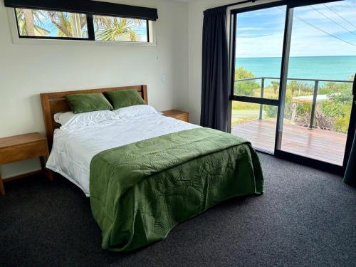 a bedroom with a bed with a view of the ocean at 45 degrees South in Kakanui