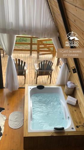 een jacuzzi in een tent met 2 stoelen bij Chalé Alto do Morro 2 - conforto e vista deslumbrante in Rancho Queimado