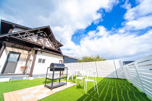 a patio with chairs and a grill in a yard at Awaji Seaside Log House in Awaji