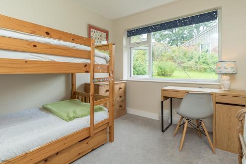 a bedroom with two bunk beds and a desk at Hendre-Llangwm in Llangwm