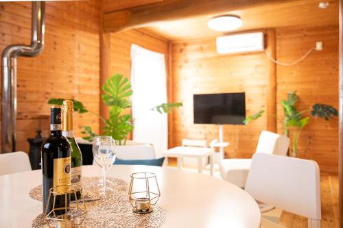 a bottle of wine on a table with glasses at Awaji Seaside Log House in Awaji
