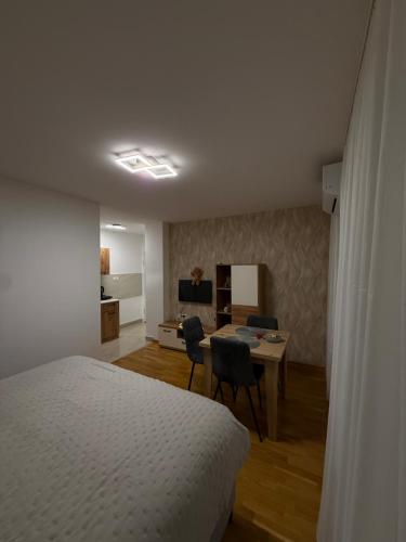 a bedroom with a bed and a desk with chairs at Apartmani Sirius in Čačak