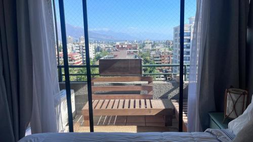 Blick auf einen Balkon mit einer Bank auf einem Gebäude in der Unterkunft Providencia, ubicación y vista extraordinaria, con AC in Santiago