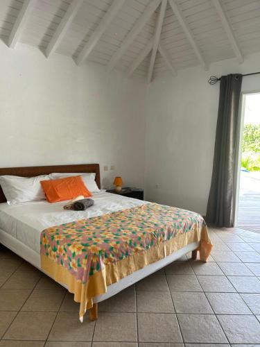 a bedroom with a bed with a colorful blanket on it at Studio Terres Basses, Saint-Martin in Les Terres Basses