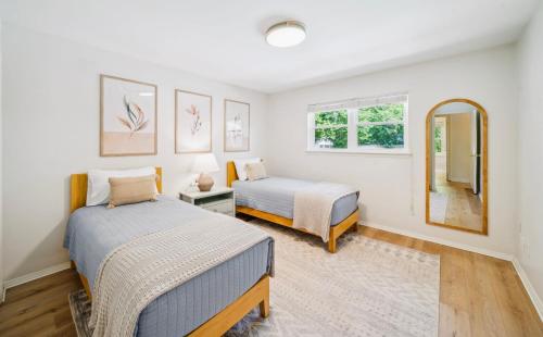 a bedroom with two beds and a mirror at Heart of Tulsa, pool, game room, Sleeps 8 in Tulsa