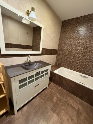 een badkamer met een wastafel, een bad en een spiegel bij Onlyroom Madrid Gabriel Usera in Madrid