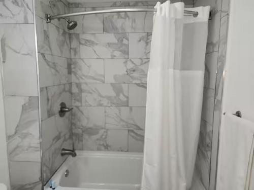 e bagno con doccia con tenda bianca. di Torraille Waterfall Villas a Soufriere