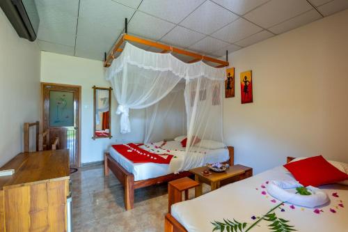 a bedroom with two beds and a canopy bed at Wild Breeze in Tissamaharama