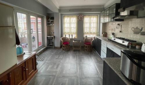 a kitchen with wooden floors and a large kitchen with windows at DND House in Pātan