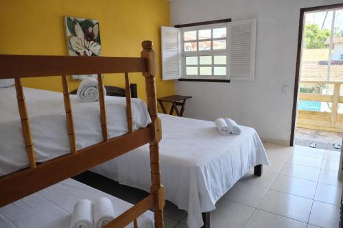 Giường trong phòng chung tại Suíte Tropicália