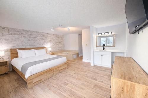 een slaapkamer met een groot bed en een bad bij King Bed, Jacuzzi, Private Balcony by Gull Lake in Nisswa