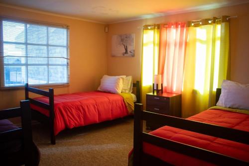 a bedroom with two beds and a window at Hostal Turpial Patagonia in Puerto Natales