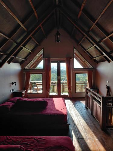 a bedroom with two beds in a room with windows at Sembalun agro villa&restoran in Sembalun Lawang