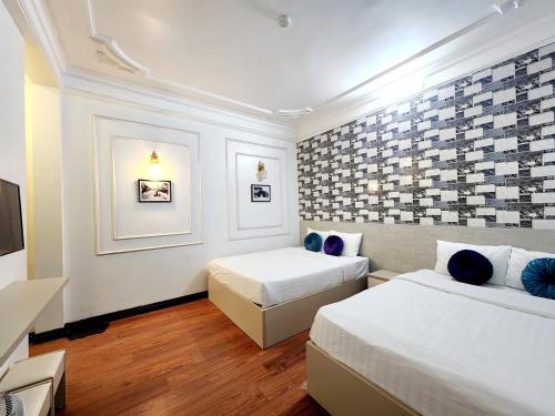 een hotelkamer met twee bedden en een tv bij The Lake Silk Hanoi Boutique Hotel & Spa in Hanoi