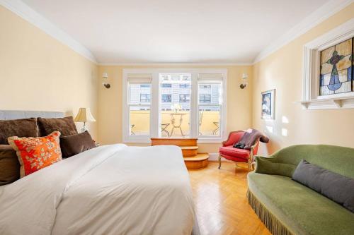 ein Schlafzimmer mit einem Bett und einer Couch und einem Fenster in der Unterkunft Nob Hill Charm in San Francisco