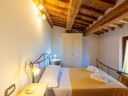 a bedroom with a bed and a lamp on a table at Apartment in a farmhouse with 2 swimming pools in Cagli