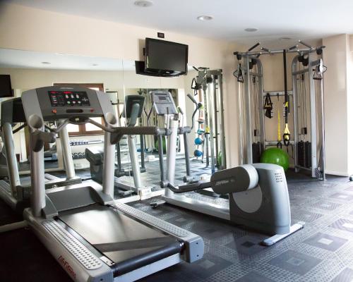 a gym with tread machines and a flat screen tv at Hotel Agora Sure Hotel Collection by Best Western in Lago Patria