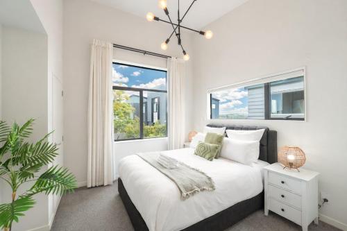 ein weißes Schlafzimmer mit einem Bett und einem Fenster in der Unterkunft Modern 4-Bedroom Home in Silverdale in Silverdale