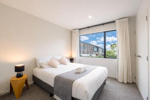 ein Schlafzimmer mit einem Bett und einem großen Fenster in der Unterkunft Modern 4-Bedroom Home in Silverdale in Silverdale