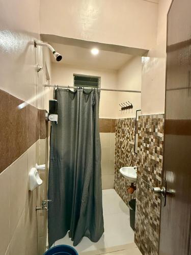 a bathroom with a shower and a sink at Violegre Homestay - KABLON in General Luna