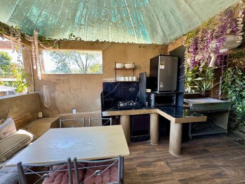 a room with a kitchen with a table and a refrigerator at Cabañita TEPOZTLÁN in Tepoztlán