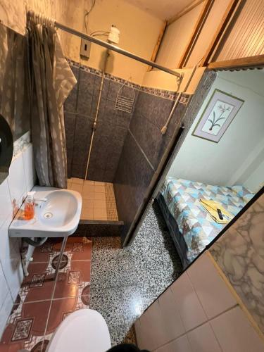 a small bathroom with a sink and a bed at Hospedaje la estrella del lago in San Juan La Laguna
