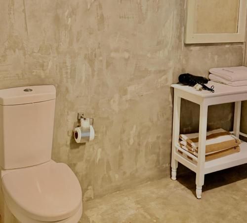 a bathroom with a white toilet and a white table at Luvora Villa in Ambalangoda