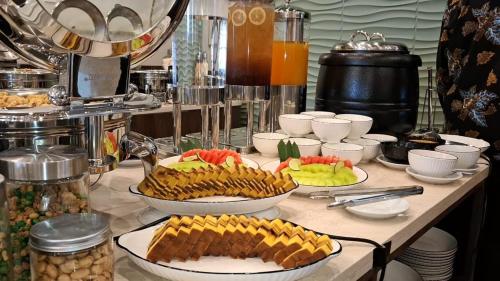 een buffet met verschillende gerechten op tafel bij Front One Hotel Mesir Surabaya in Surabaya