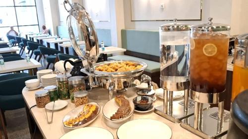 een buffet met eten en drinken op een tafel bij Front One Hotel Mesir Surabaya in Surabaya