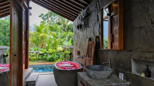 a bathroom with a tub and a sink at Sanis House in Penginyahan