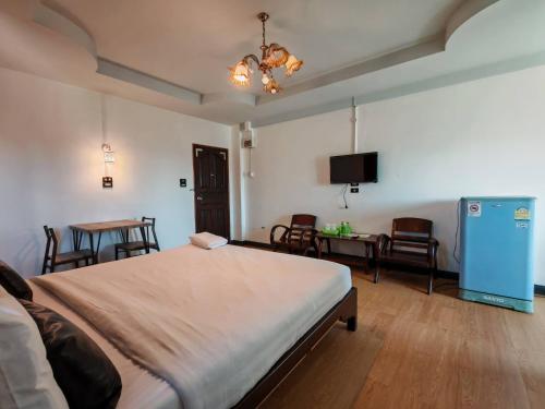 una camera da letto con un letto, un tavolo e delle sedie di Erawan in a Mae Sot