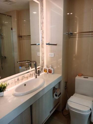 a bathroom with a sink and a toilet and a mirror at City Garden Olympus Condo By Vacation Vibes in Pattaya South