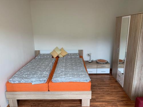 a bedroom with a bed with an orange mattress at Útulný apartmán v Jizerkách in Hejnice