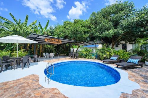 a swimming pool with a table and chairs and an umbrella at Villa Tranquila - Paraíso Privado con Piscina y Amplios Espacios Naturales con Casa Campestre in Ricaurte