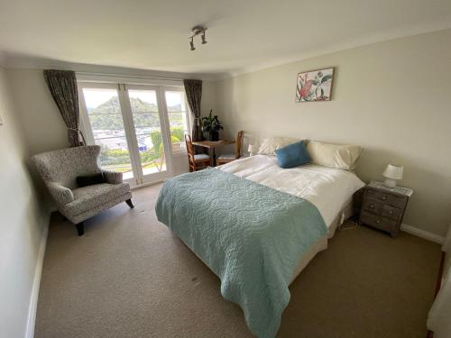 ein Schlafzimmer mit einem Bett, einem Stuhl und einem Fenster in der Unterkunft Milberry House in Picton