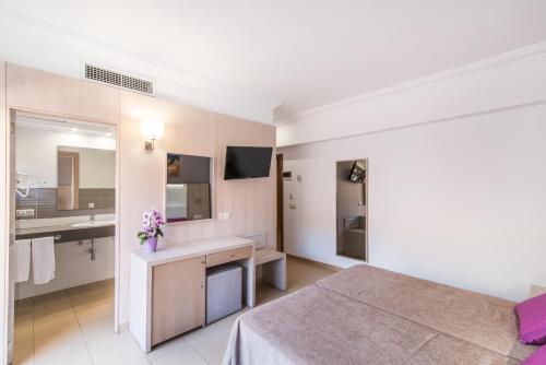 a hotel room with a bed and a sink at Hotel Baviera in Cala Ratjada