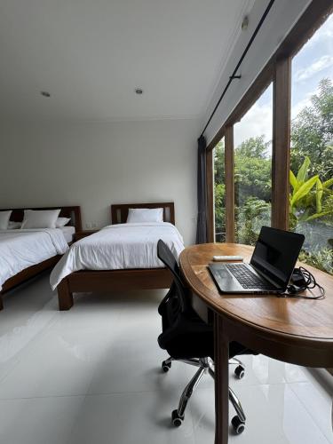 a bedroom with a desk with a laptop on it at Pier26 Bali Homestay in Nusa Dua