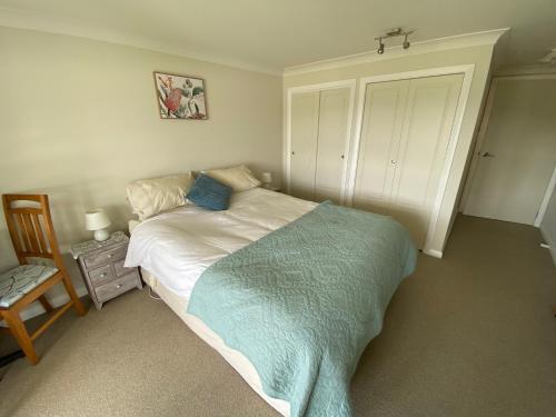 ein Schlafzimmer mit einem Bett mit einer blauen Decke in der Unterkunft Milberry House in Picton