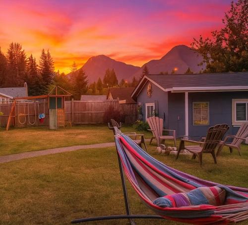 eine Hängematte im Garten eines Hauses bei Sonnenuntergang in der Unterkunft Cozy Cedar Nook in Hope