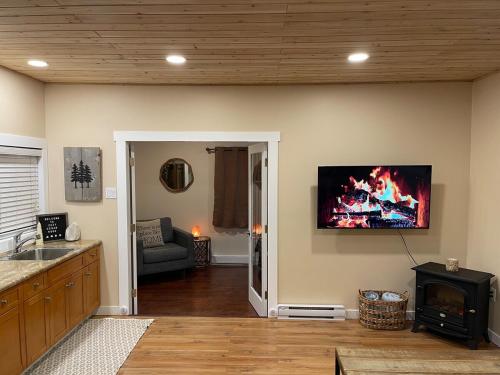 ein Wohnzimmer mit einem Kamin und einem TV an der Wand in der Unterkunft Cozy Cedar Nook in Hope