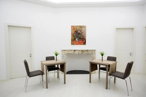 a dining room with two tables and chairs and a painting at Alberica10 in Carrara