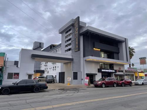 a building with cars parked in front of it at Hotel Frontera Baja in Mexicali
